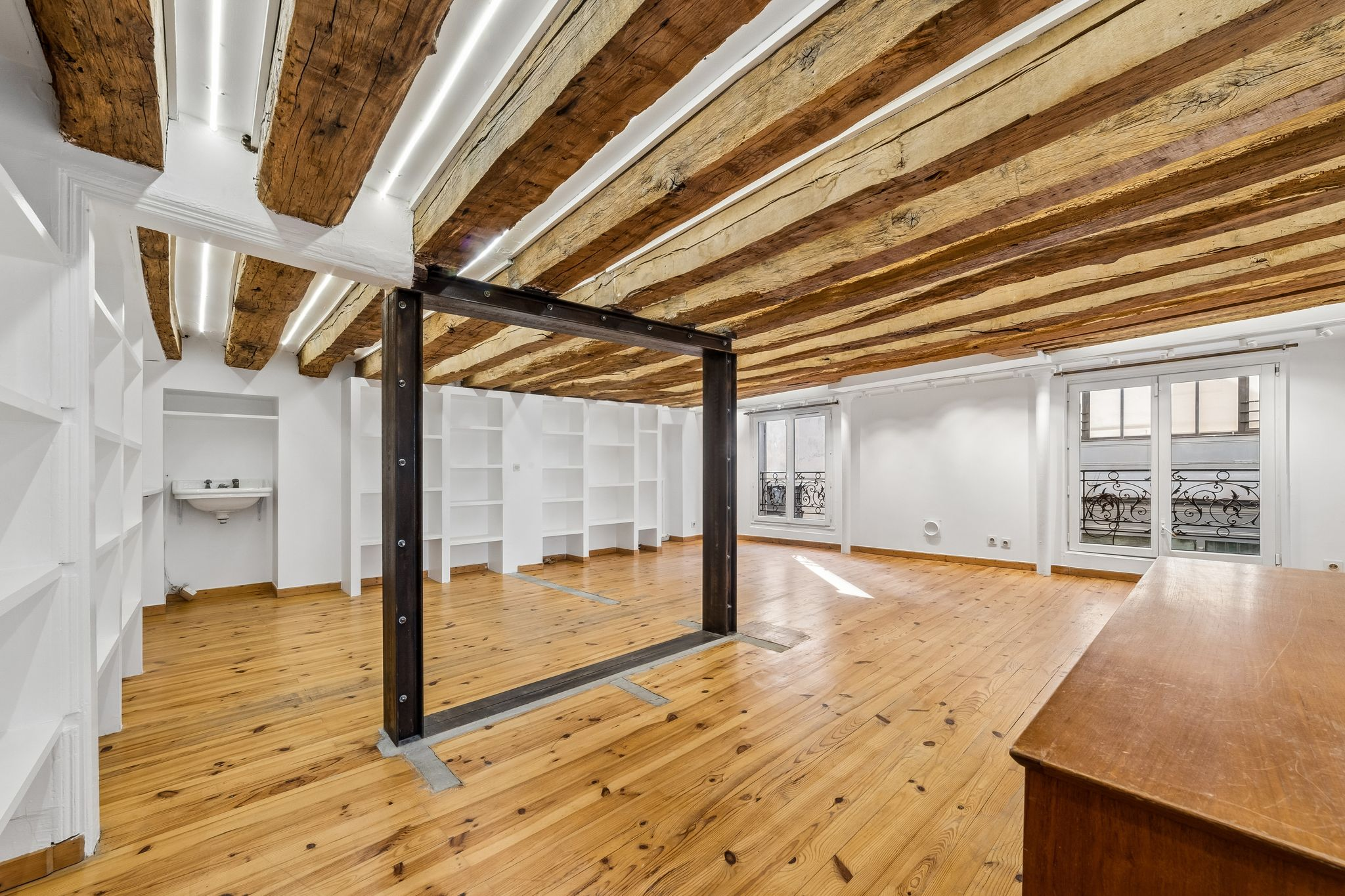 Salle avec poutres apparentes et rangements