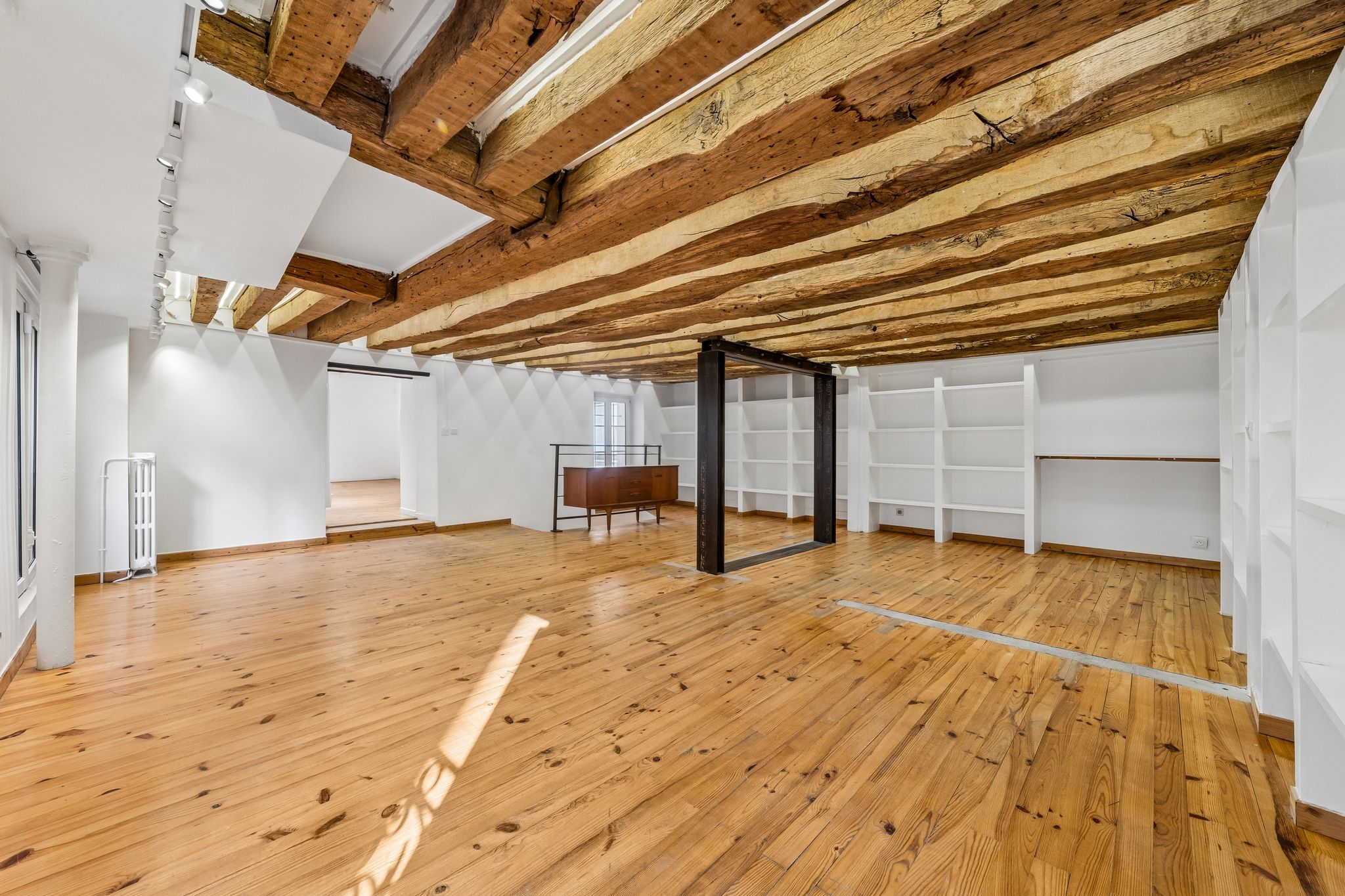 Grande salle avec poutres historiques apparentes